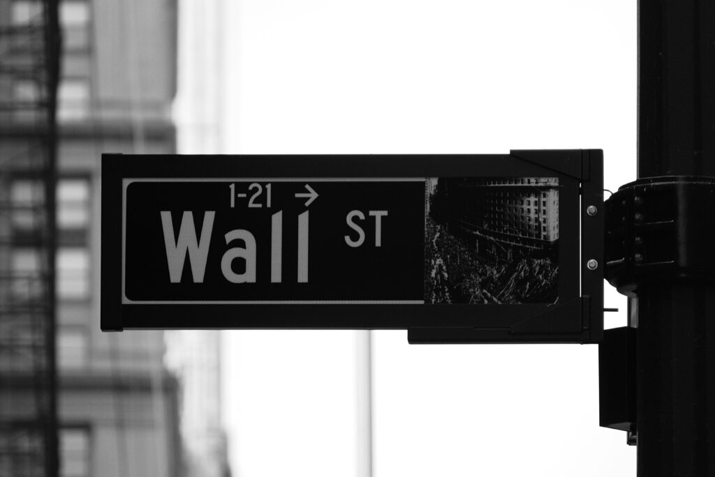Wall Streetの標識を写した白黒写真。株式投資のイメージであり、本人の口座画面や運用成績ではありません。